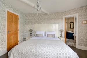 a bedroom with a large white bed and a bathroom at 3 Bed in Fowey oc-p00647 in Fowey