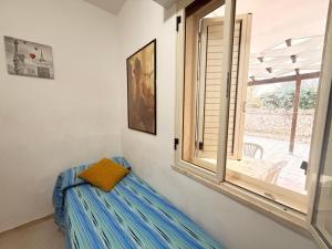 a room with a window and a bench with a pillow at Baia Incantata in Baia Verde