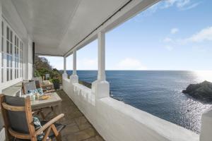 a balcony with a table and chairs and the ocean at 3 Bed in Polperro oc-h34100 in Polperro