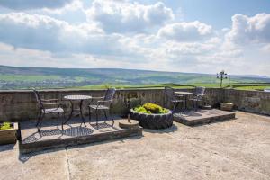 a patio with chairs and a table and a flower pot at 1 Bed in Cowling oc-ds237 in Cowling