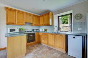 a large kitchen with wooden cabinets and a window at 1 Bed in Cowling oc-ds237 in Cowling