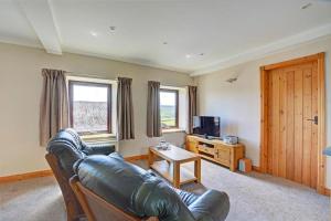 a living room with a leather couch and a television at 1 Bed in Cowling oc-ds237 in Cowling