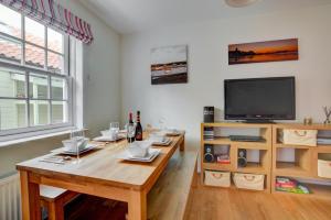 a living room with a wooden table and a tv at 4 Bed in Cromer oc-1942 in Cromer
