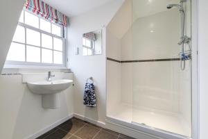 a white bathroom with a sink and a shower at 4 Bed in Cromer oc-1942 in Cromer +9 photos