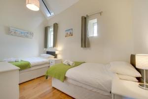 two beds in a room with white walls at 2 Bed in Totnes oc-bcteig in Broadhempston +8 photos