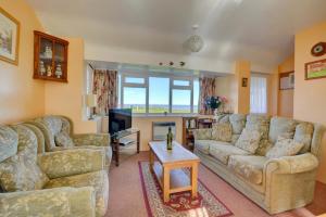 a living room with two couches and a table at 2 Bed in Mundesley oc-673 in Mundesley