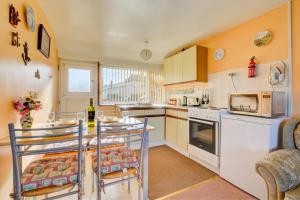 a kitchen with white appliances and a table and chairs at 2 Bed in Mundesley oc-673 in Mundesley +4 photos