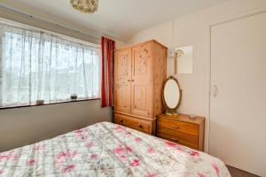 a bedroom with a bed and a dresser and a mirror at 2 Bed in Mundesley oc-673 in Mundesley