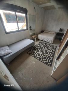 ein kleines Zimmer mit zwei Betten und einem Teppich in der Unterkunft Casa do Steve in Florianópolis