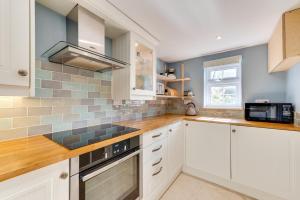 a kitchen with white cabinets and a microwave at 2 Bed in Sweffling oc-whcs in Rendham