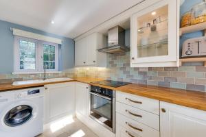 a kitchen with white cabinets and a washer and dryer at 2 Bed in Sweffling oc-whcs in Rendham +3 photos