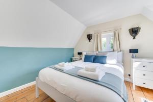 a bedroom with a large white bed with blue accents at 2 Bed in Sweffling oc-whcs in Rendham