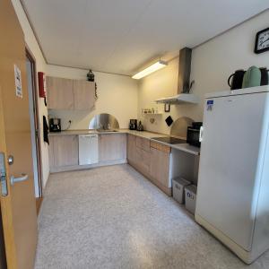 a large kitchen with a white refrigerator in it at Lysbjerggård in Faaborg