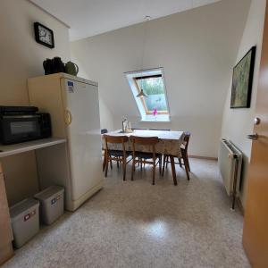 a kitchen with a dining room table and a refrigerator at Lysbjerggård in Faaborg