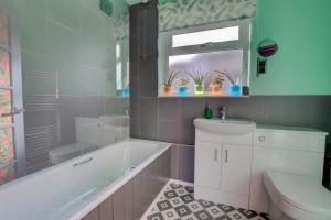 a bathroom with a tub and a toilet and a sink at 2 Bed in Felixstowe oc-hideo in Felixstowe