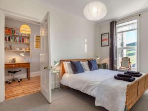 a bedroom with a bed and a desk and a window at 4 Bed in Woolacombe oc-90224 in Mortehoe