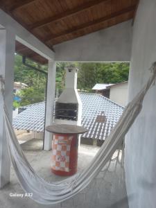 eine Hängematte auf einer Terrasse mit einem Herd in der Unterkunft Casa do Steve in Florianópolis
