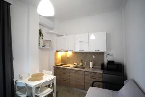 a small kitchen with a white table and a white table at AsproLux Seaside Studios in Asprovalta