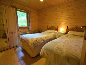 a bedroom with two beds in a log cabin at 3 Bed in Glenfinnan oc-cabin in Glenfinnan