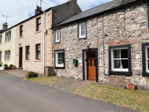 an old stone building with a brown door on a street at 2 Bed in Penrith oc-sz276 in Stainton