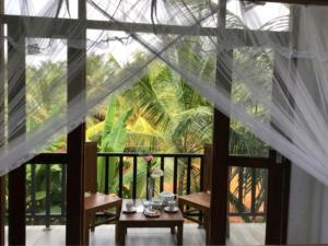 a room with a balcony with a view of a palm tree at Lucky Palace in Beruwala