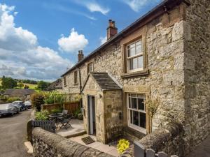 an old stone house with a patio in front of it at 2 Bed in Matlock oc-77632 in Brassington