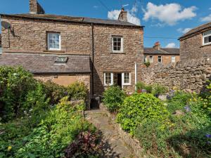 a stone cottage with a garden in front of it at 2 Bed in Kirkby Stephen oc-sz144 in Kirkby Stephen