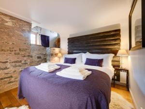 a bedroom with a purple bed with towels on it at 5 Bed in Selkirk oc-tower in Selkirk