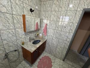 a bathroom with a sink and a mirror at Refúgio Hostel Unidade 3 in Bauru +45 photos