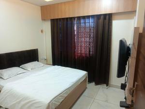 a bedroom with a bed and a television and a window at Hotel Jayaswal INN in Bharbharia