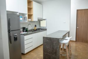 a kitchen with a stainless steel refrigerator and white cabinets at Depto. 2 rec. con acceso al Río in Boca del Río