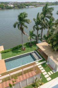 a swimming pool with palm trees and a body of water at Depto. 2 rec. con acceso al Río in Boca del Río