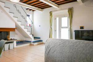 a living room with a staircase and a table at InnPisaRentals - Cozy Flat by the Airport in Pisa