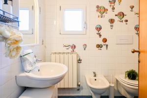 a bathroom with a sink and a toilet and balloons on the wall at InnPisaRentals - Cozy Flat by the Airport in Pisa