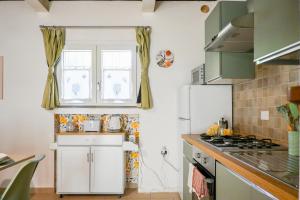 a kitchen with a white refrigerator and a window at InnPisaRentals - Cozy Flat by the Airport in Pisa