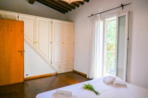 a room with a bed and a large window at InnPisaRentals - Cozy Flat by the Airport in Pisa +45 photos