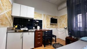 a kitchen with white cabinets and a counter top at Apartman Perper in Trebinje