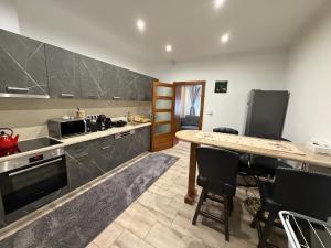a kitchen with a counter and a table and chairs at Barackvirág-Vendégház in Érpatak