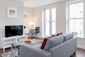 a living room with a couch and a tv at Roomspace Serviced Apartments - Trinity House in Reigate