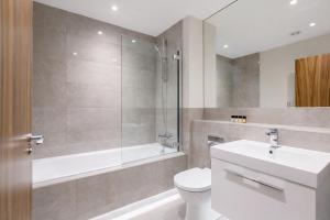 a bathroom with a toilet and a tub and a sink at Roomspace Serviced Apartments - Trinity House in Reigate +12 photos