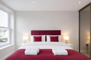 a bedroom with a large bed with two pillows at Roomspace Serviced Apartments - Trinity House in Reigate