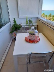 a small white table in a room with a window at La Goelette 4 in Toulon