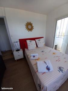 a bedroom with a large bed with white sheets and pillows at La Goelette 4 in Toulon