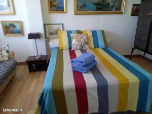 a bedroom with a colorful bed with towels on it at La Goelette 4 in Toulon