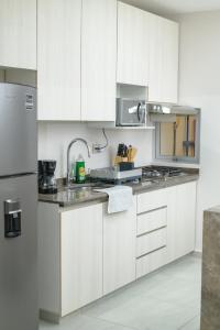 a kitchen with white cabinets and stainless steel appliances at Depto. 2 rec. en Playa Mocambo in Boca del Río