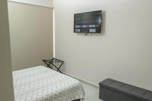 a room with a bed and a tv on the wall at Depto. 2 rec. en Playa Mocambo in Boca del Río