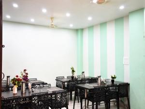 a dining room with tables and chairs and a striped wall at HOTEL ATA INN AND RESTAURANT (20 Mtrs from Dargah), Ajmer in Ajmer