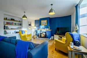a living room with blue walls and yellow chairs at 3 Bed in Kelling oc-w27424 in Kelling