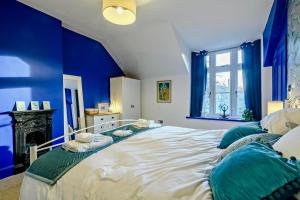 a blue bedroom with a large bed with blue walls at 3 Bed in Kelling oc-w27424 in Kelling