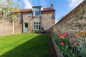 a brick house with a garden and flowers at 3 Bed in Kelling oc-w27424 in Kelling